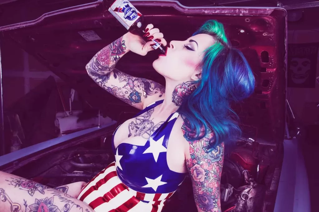 emo girl drinking beer on a car