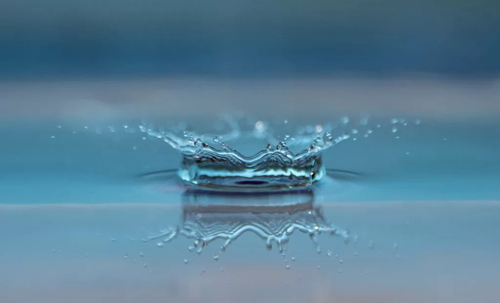 Close up money shot of a raindrop hitting water